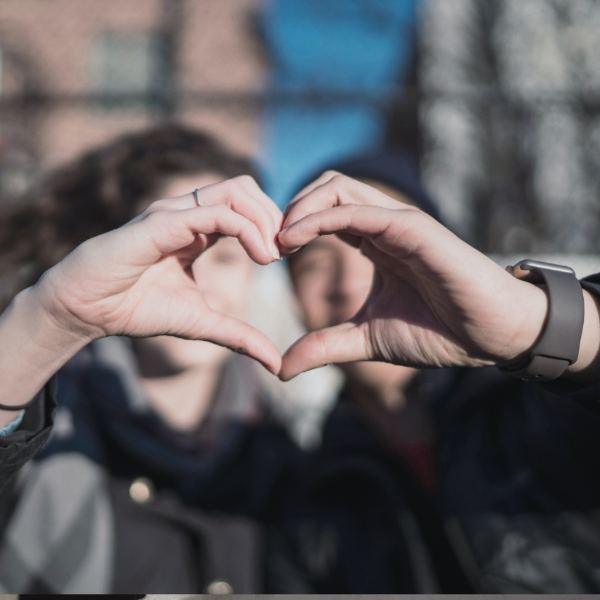 Two people making heart shapes with their hands